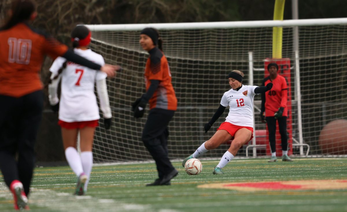 CLEAR! Junior Abigayle Bates kicks the ball out, trying to pass it to her teammate on the other side against Alivin on Friday, Jan. 10, 2025.