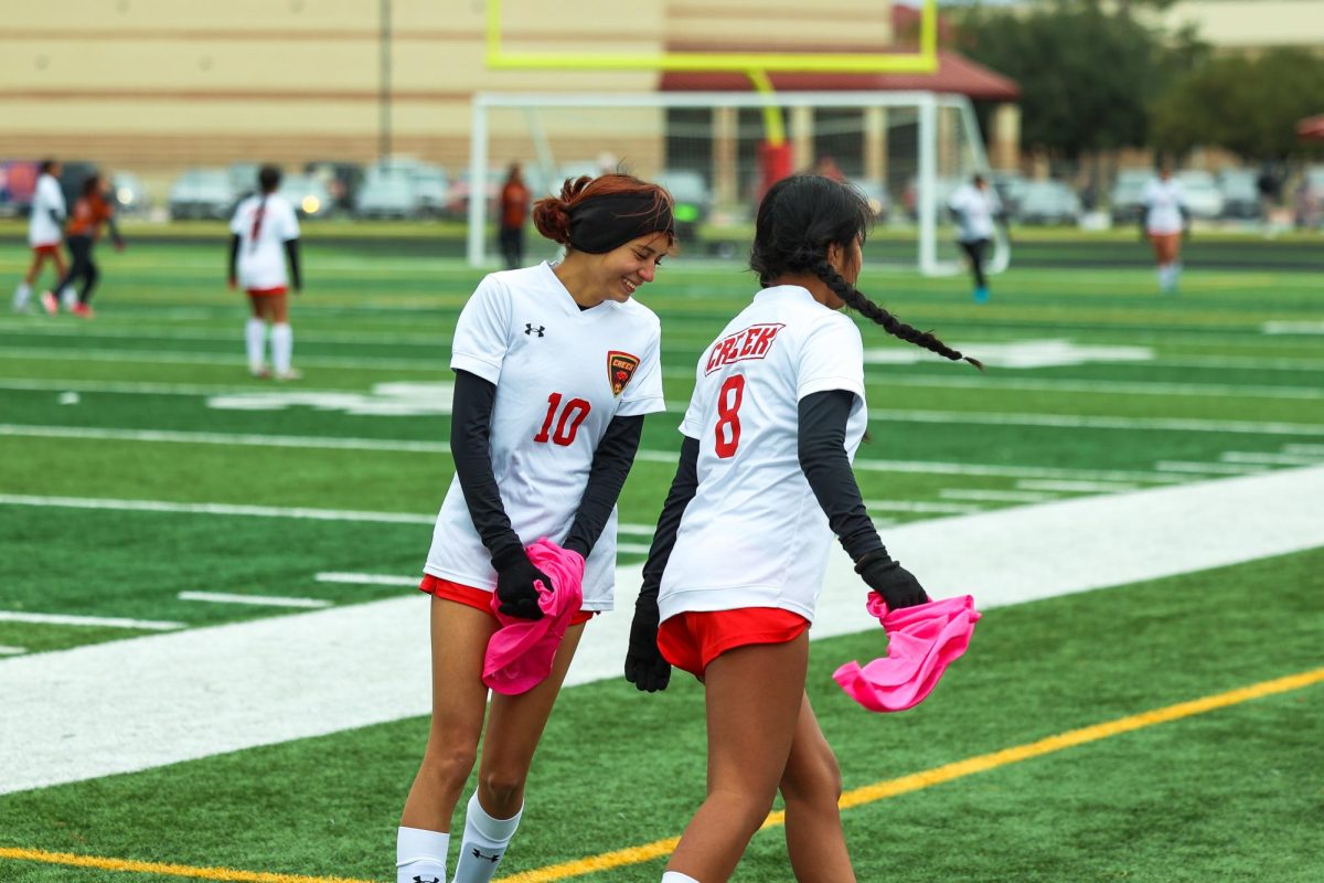 WARMING UP. Junior Emily Rosales and Freshmen Monserrath Mendoza jog in a circle, so as to not get cold standing around during the game against Alvin High School on Friday, Jan. 10, 2025. “I was excited to go in,” Rosales said. “The thing I didn't like was waiting in the cold.”