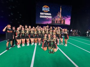 The cheer team poses with their silver medals and trophy at the National High School Cheer Championship in Orlando, Florida. The cheer team placed second overall in Coed Varsity game day performance.