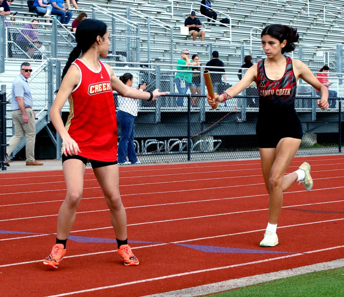 PUSHING LIMITS. Junior Emily Rosales passing the bar to Alia Osorto. Emily was later running the 4x4.” i felt a lot of pressure on running the mile bc my whole mind set at that moment was to keep my pace and to pass people up to keep the momentum going and when passing the bar to Alia all i thought was to keep running until i couldn’t because at least i knew that i tried my best .”