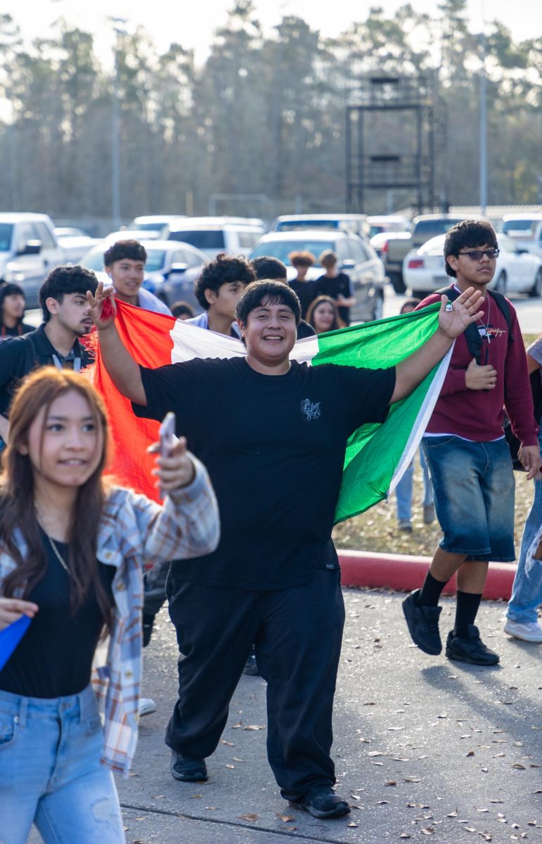 WE ARE IMPORTANT. A student walks with a Mexican flag alongside other students to support immigrants who are too afraid to themselves Tuesday, Feb. 4, 2025.