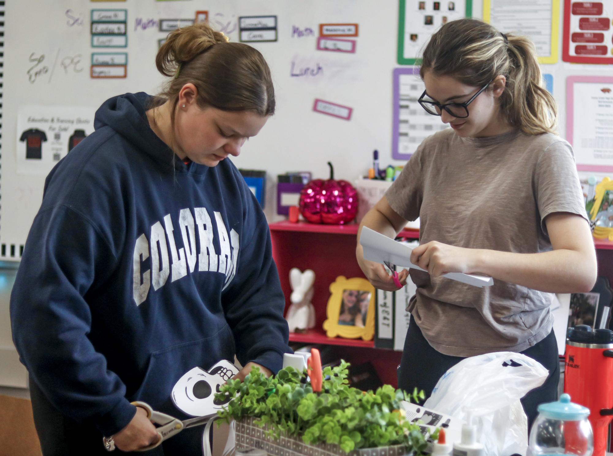 Junior Samantha Reese(left) and Junior Sara Wilkins(right) cut out Halloween decorations during a TAFE meeting on Oct. 16. Reese was elected as the TAFE president this year following her success at TAFE area competitions last year.