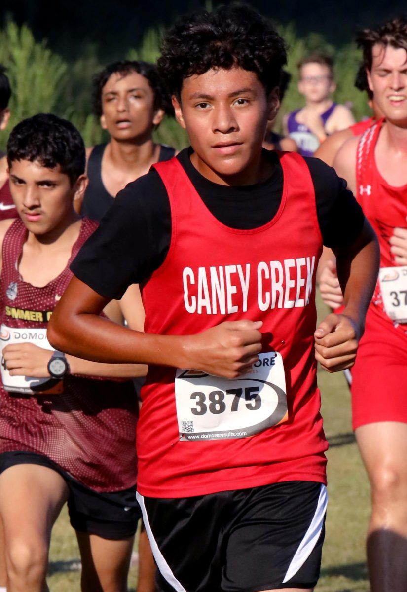BOLD CHARGE. Sophomore Noel Vazquez charges ahead of the other runners with a smile on Sep. 13 at the Dayton Invitational Meet. Vazquez continues to push, marking his debut race on the junior varsity team.
