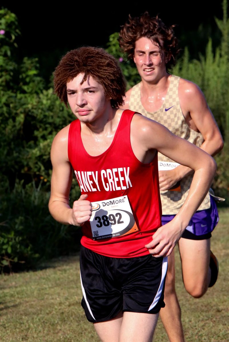 LONG STRIDE. Junior Xander Boulanger charges ahead of the other runners at the Dayton Invitational Meet on Sept. 13. Boulanger would continue sprinting ahead of multiple runners towards his second lap.