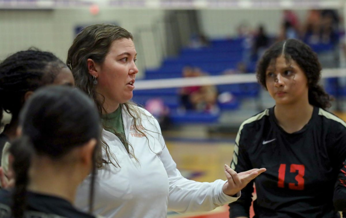 NEW PLAN. Coach Samantha Lang gives the Freshman players a pep talk at the Volleyball V. Oak Ridge game on Sept. 19. Lang would help the team better their defense against Oak Ridge.