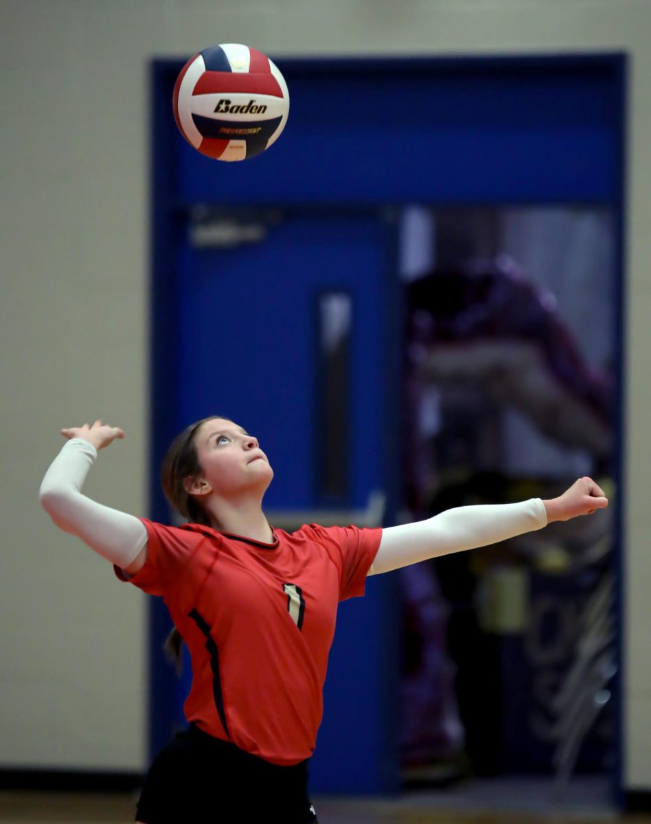 SURGE. Freshman Kambryn Herrell serves the ball at the Volleyball V. Oak Ridge game on Sept. 19th. Herrell would serve the ball multiple times throughout the game, aiming for a point.