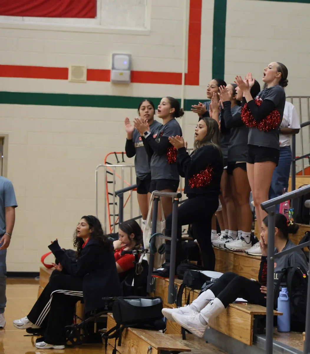 CHEERING ON. During the game against The Woodlands on Tuesday, September 2, Kaelin Berset (12) and Marci Villegas (12) were cheering on JV with pom poms to help encourage them while they're playing. “The pom poms stunk so none of the other girls were cheering because they stunk but I was going crazy with them,” Berset said.