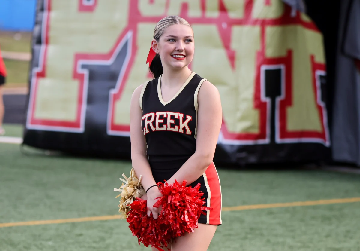 LEAD THE WAY. Junior Jade Bradley led the way for seniors and their parents during senior night on Aug.29, 2025. The Caney Creek cheerleaders were helping keep the line of seniors with their families going smoothly. 