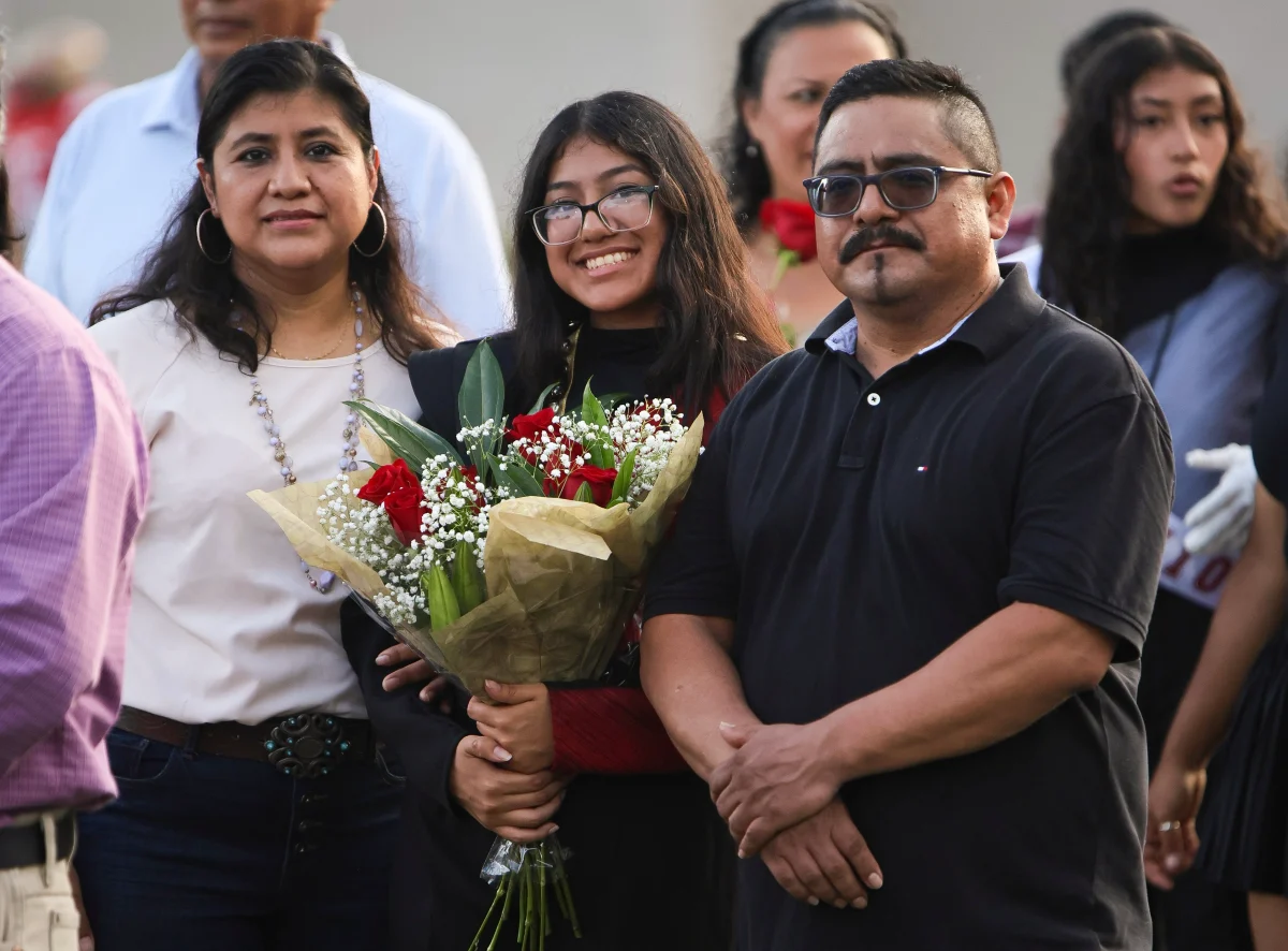 CAPTURING THE MOMENT. Senior Karol Nahuactl took a photo with her parents while they waited for her name to be called during senior night on Aug.29, 2025. The seniors from the Mighty Panther Band alongside some organizations from Caney Creek High School walked with their parents before the Football home game VS Waller.