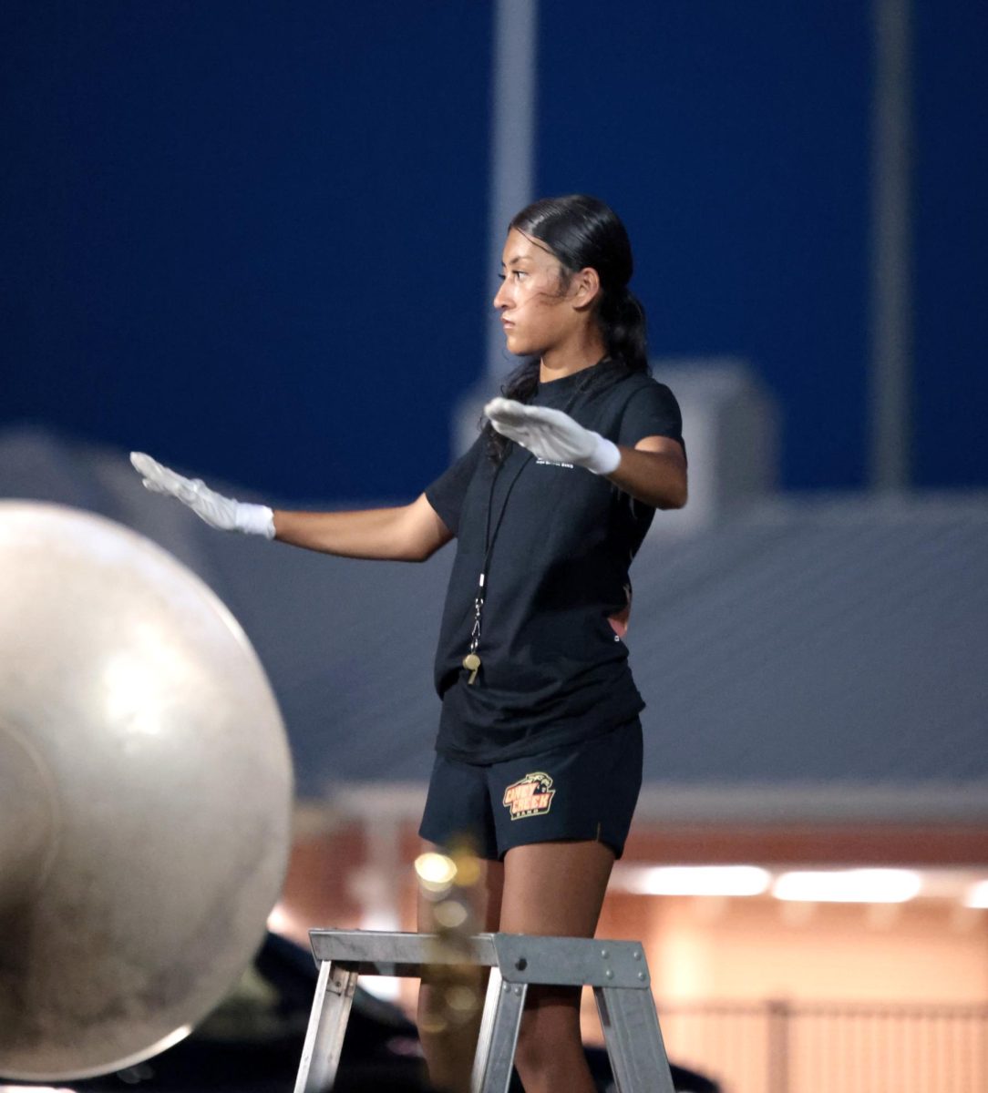 STEADY HANDS. Senior Analily Organes was directing the band before the half-time performance on Sept. 5, 2025.  “ I don’t get nervous at all , I focus myself and make sure that the band is on tempo and not out of tune,” Organes said.