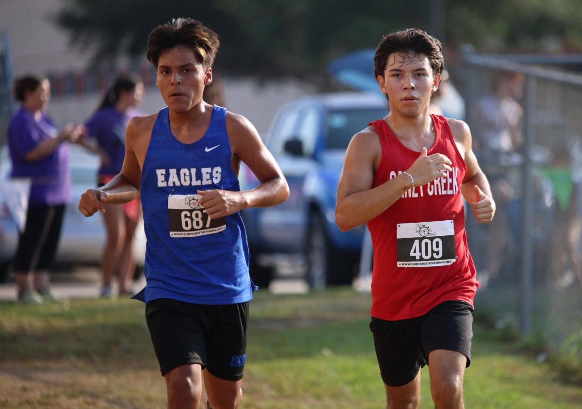 BATTLE Sophomore Jesse Harjo was battling to get in front of his opponent during the Longhorn Stampede meet on Sept. 18, 2025.  “I'm on my second lap and im getting closer to the finish, i was next to this kid and he was elbowing,” Harjo said. “I realized whatever happens, happens it's in God's plan and I'm going to push myself and maybe PR.”