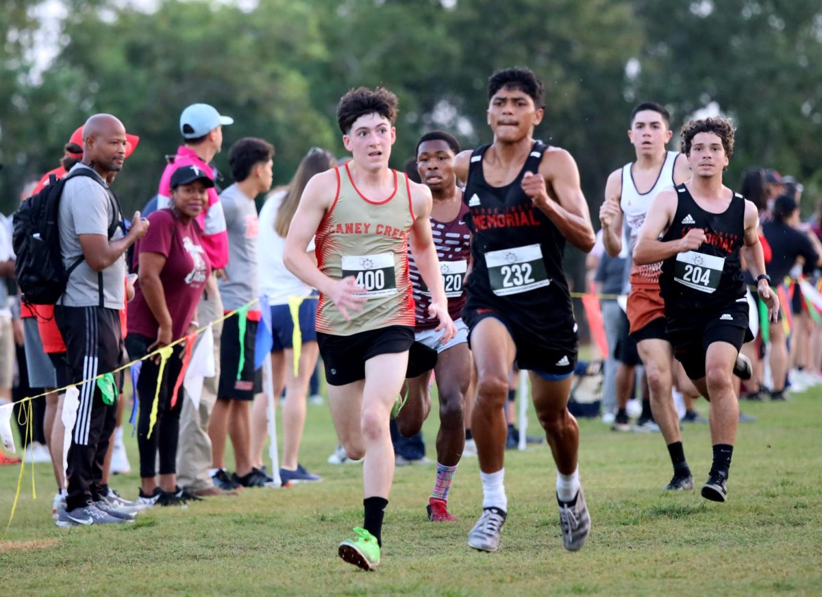 SHOOT. Freshman Jett Banes sees someone passing and takes the chance to show how fast he is during the Longhorn Stampede meet on Sept. 18, 2025.  Banes got 6th place out of 180 and felt good after the race, not feeling tired. “I felt good, it was a 5k so i try to start out strong and then stay consistent through it and then finish strong at the end,” Banes said. “After the race I didn't even feel tired, I didn't realize we were finishing till the end.”