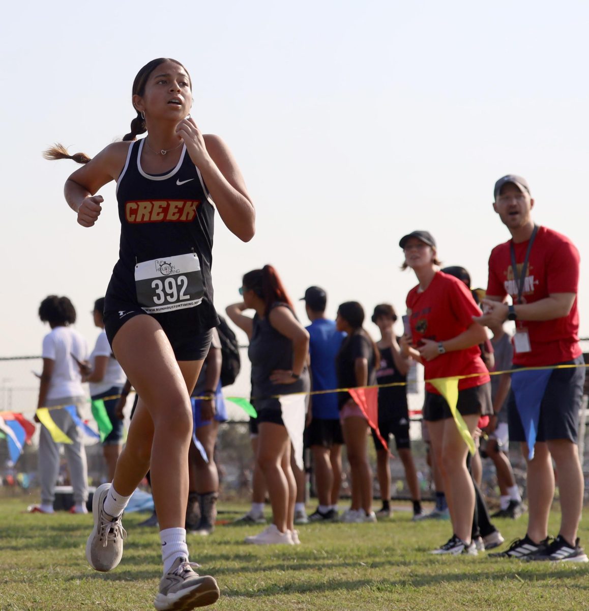 RUN FOREST RUN. Freshman Gracie Hernandez runs her 2 mile race with her coaches cheering her on during the Longhorn Stampede meet on Sept. 18, 2025.  After the race she was tired, and hungry, on the way back to school the team went to Raising Canes where enjoyed her meal and time with her friends. “ I was running my 2 mile, it was hot and I was hungry,” Hernandez said. “I think I got 42 out of like 600 girls and I felt like I could've done better because I was top 20 and the second mile killed me.”