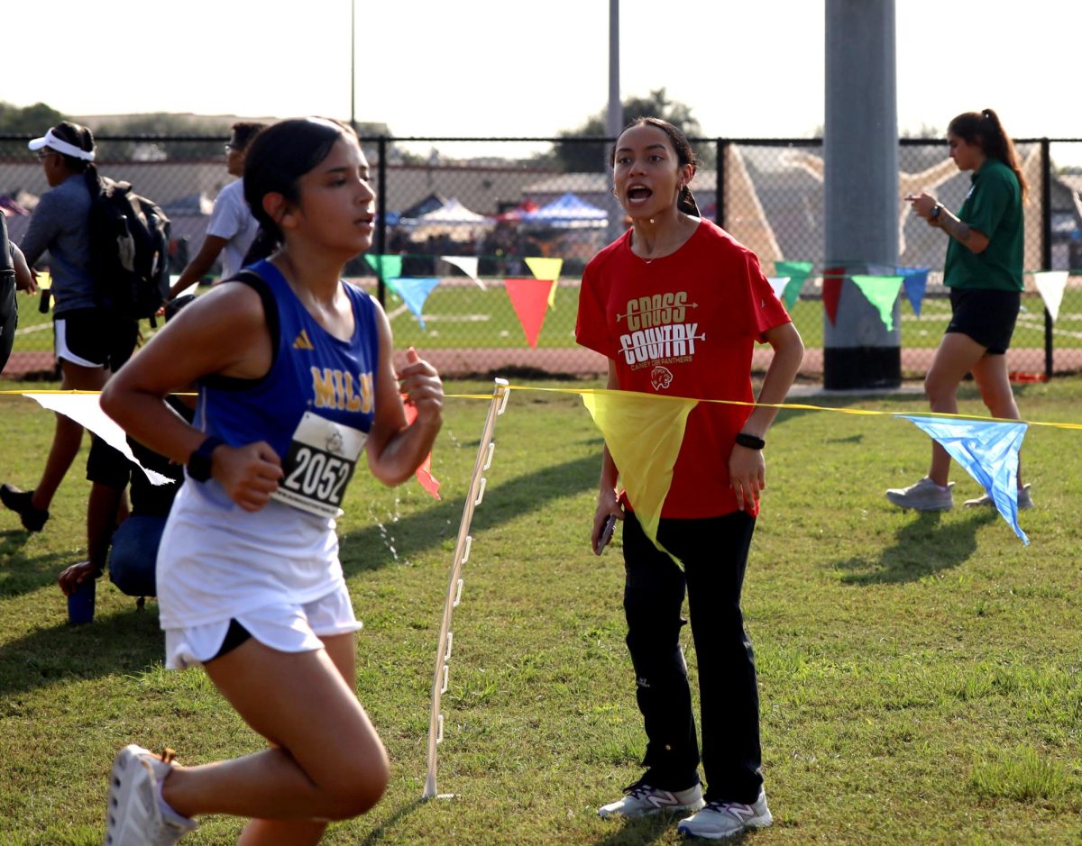 SCREAM AND SHOUT. Junior Alia Osorto cheers for her team while being injured, during the Longhorn Stampede meet on Sep. 18, 2025.  “I was cheering for my team since that's all I can do since I'm injured,” Osorto said. “I just feel bad like if its silent and then no one is cheering for them I think that is really messed up, because like we all decided to get up at 5 or 4 in the morning and that most people don't do it so what they're doing is pretty hard and deserved a little cheer up.”