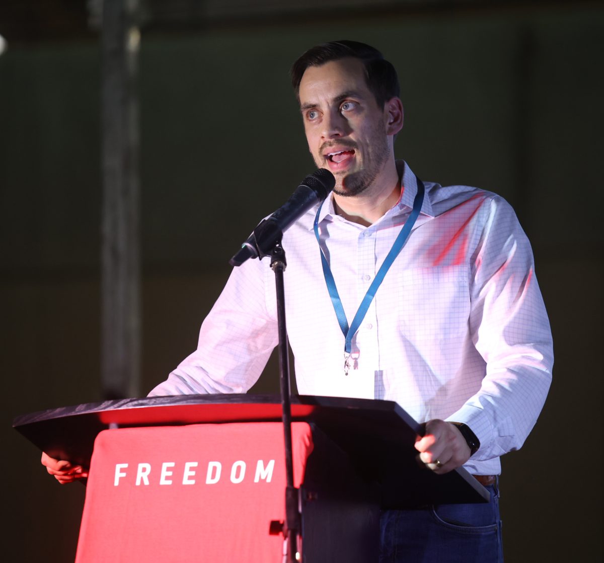 SHADOWED. Texas Youth Summit Founder Christian Collins speaks at the Montgomery Fairgrounds podium during the Charlie Kirk memorial service Sept. 30. The Youth Summit is a non-profit hosting political and religious leaders looking to educate high school and college-age youth with Judeo-Christian and Conservative values.