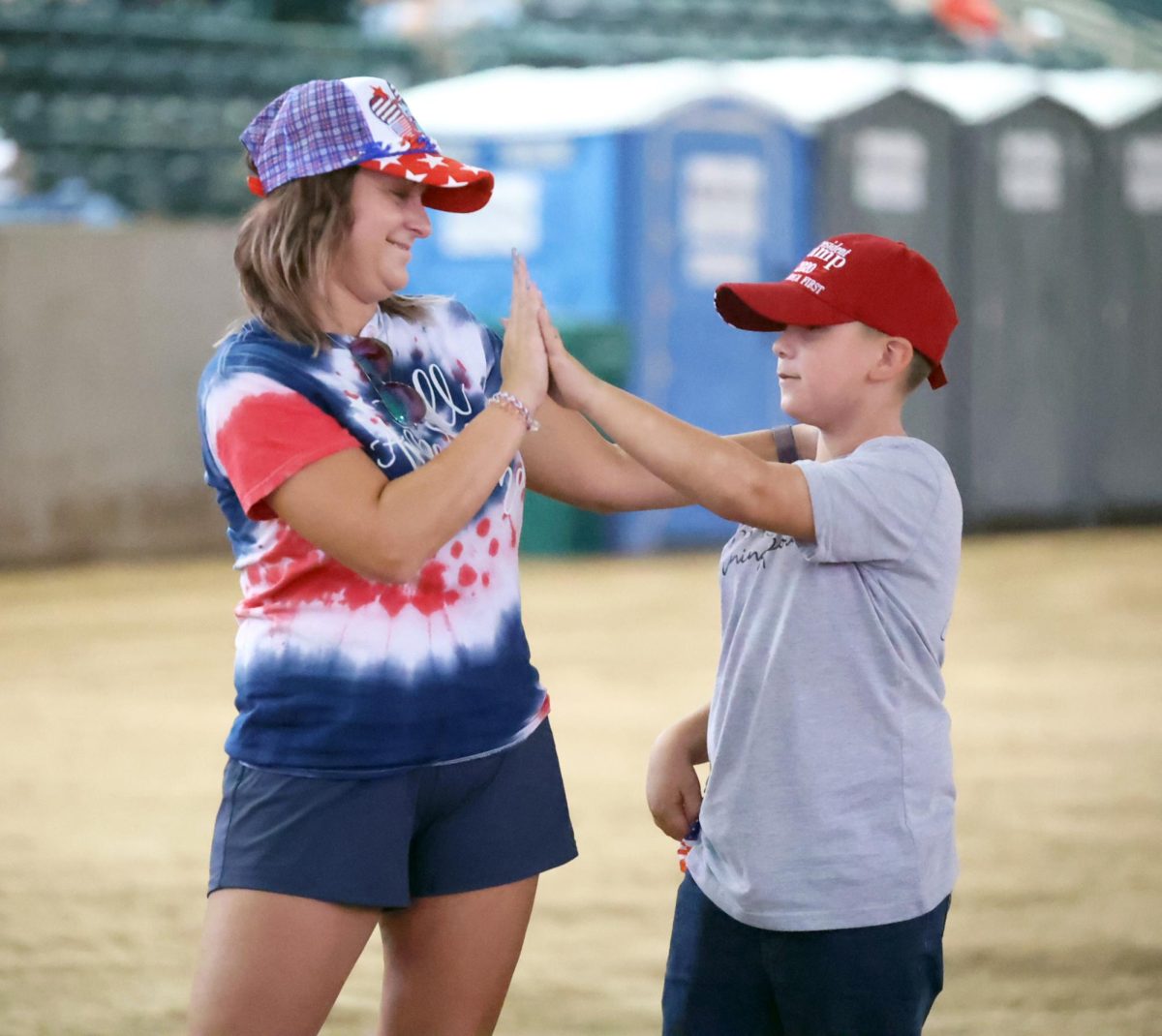 FAMILY OVER FEAR. Audience member high fives her son in the Montgomery Fairgrounds stadium general admission during the Charlie Kirk Memorial Service Sept. 30. Between memorial speeches, videos and audio, speakers encouraged family bonding.