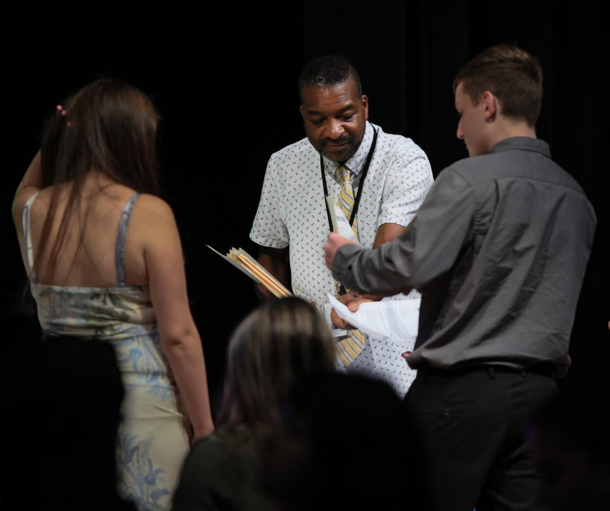 HELPING HAND. National English Honors Society sponsor, Mr. Taylor was helping out students with their new certificates on Sept. 9, 2025. NEHS was hosting an induction ceremony where they recognized the new members.