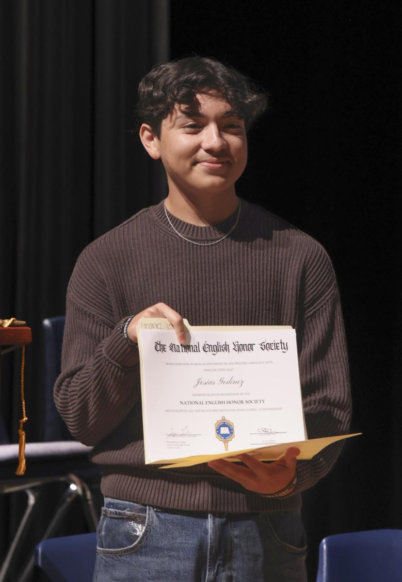 Happiness. Junior Josias Godinez was smiling while taking a photo with his certificate after the Nehs induction ceremony on Sept. 9. Godinez was excited for what is to come and the opportunity to be in NEHS.