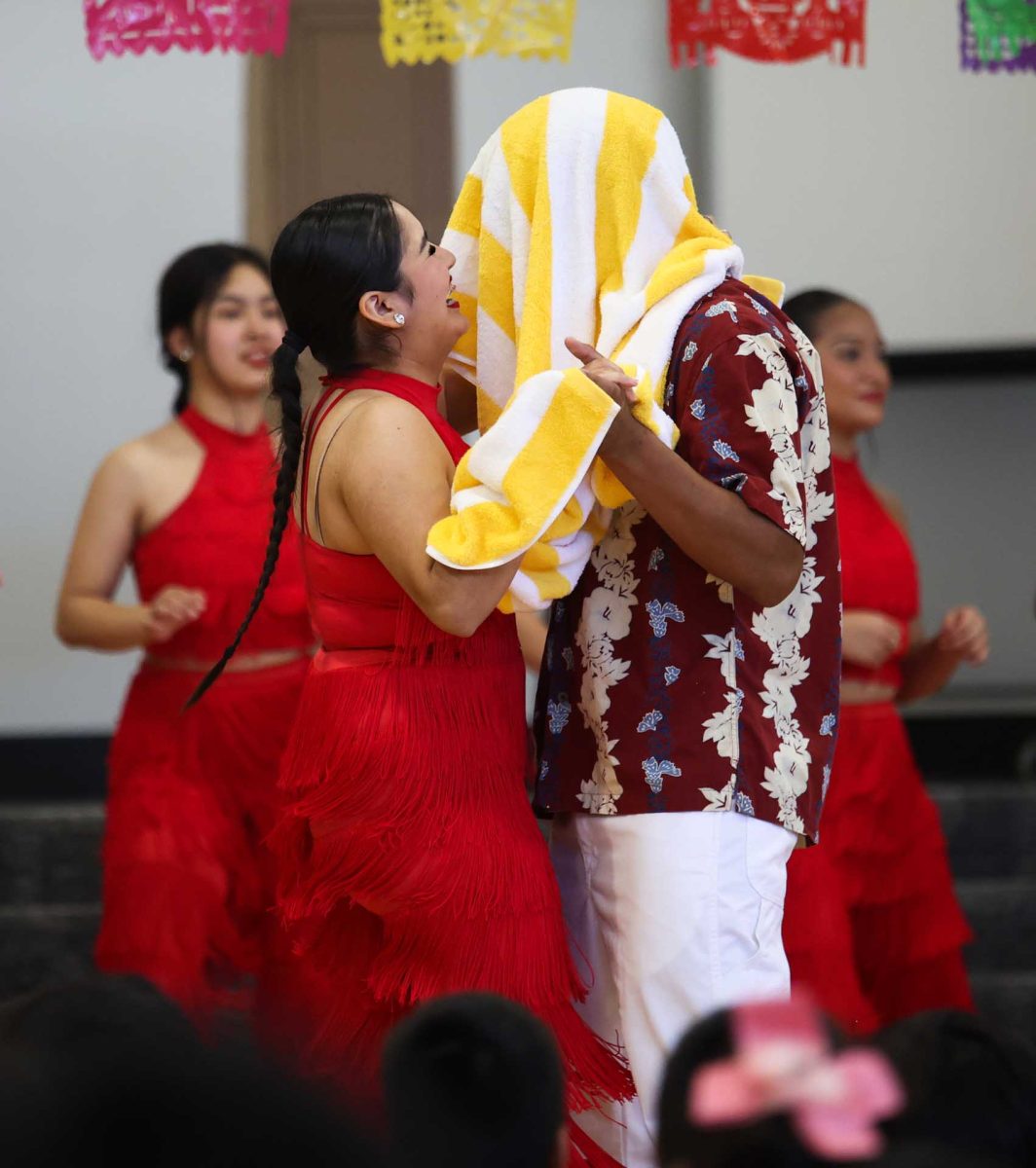 TANGLED UP. Senior Soraya Ortega accidentally throwing her towel over her dance partner, junior Kristopher Gorillo’s head, causing her to burst out into laughter as they try to play it off on Oct. 9, 2025 at Creighton Elementary. “It’s been happening a lot. I just couldn’t get it around his head. We saw it coming, so we just laughed it off,” Ortega said.
