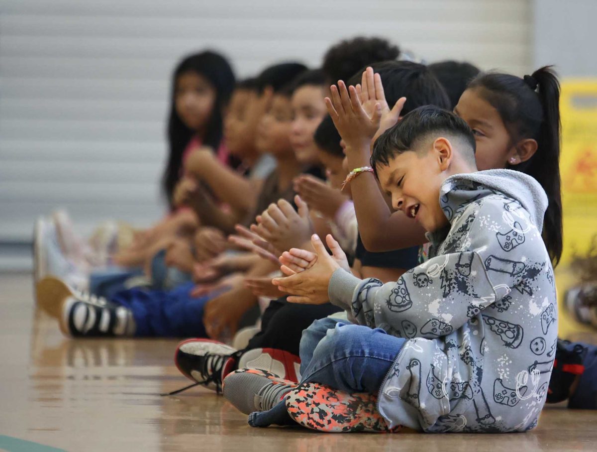 FEELING THE GROOVE. A student at Creighton Elementary School clapping and singing along to the music that plays as Panteras En Fuego perform on Oct. 9, 2025. All of the students cheered and danced as the dancers performed.