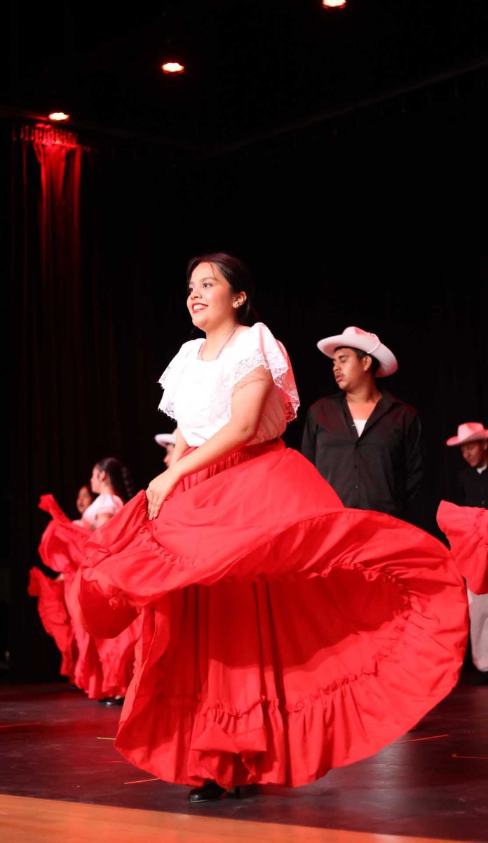 SWINGING AND DANCING. Senior Vianney Olvera twirls her dress, dancing for the Moorhead students during their students lunches on Tuesday, Oct. 14, 2025. "I think we did well,” Olvera said. “Even though there were people missing, we did a good job. Nobody made big mistakes, so it was fine."