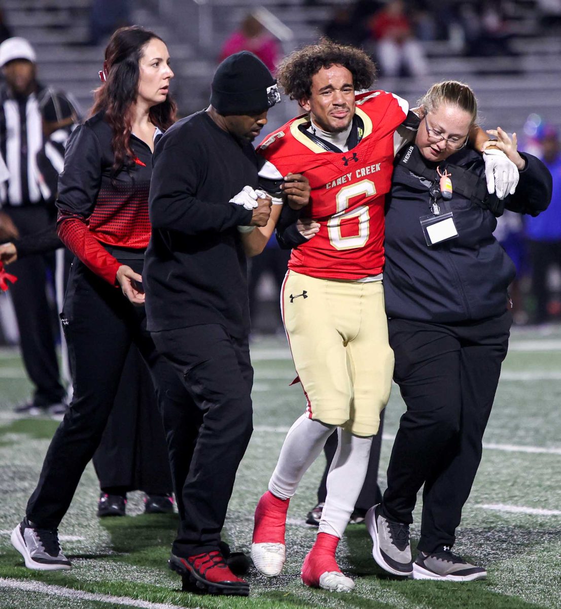 SILENT TURF. Sophomore Aaron Williams sustains a significant ankle injury during the last home football game against Oak Ridge. While Williams was on the floor, the entire court knelt and went silent.