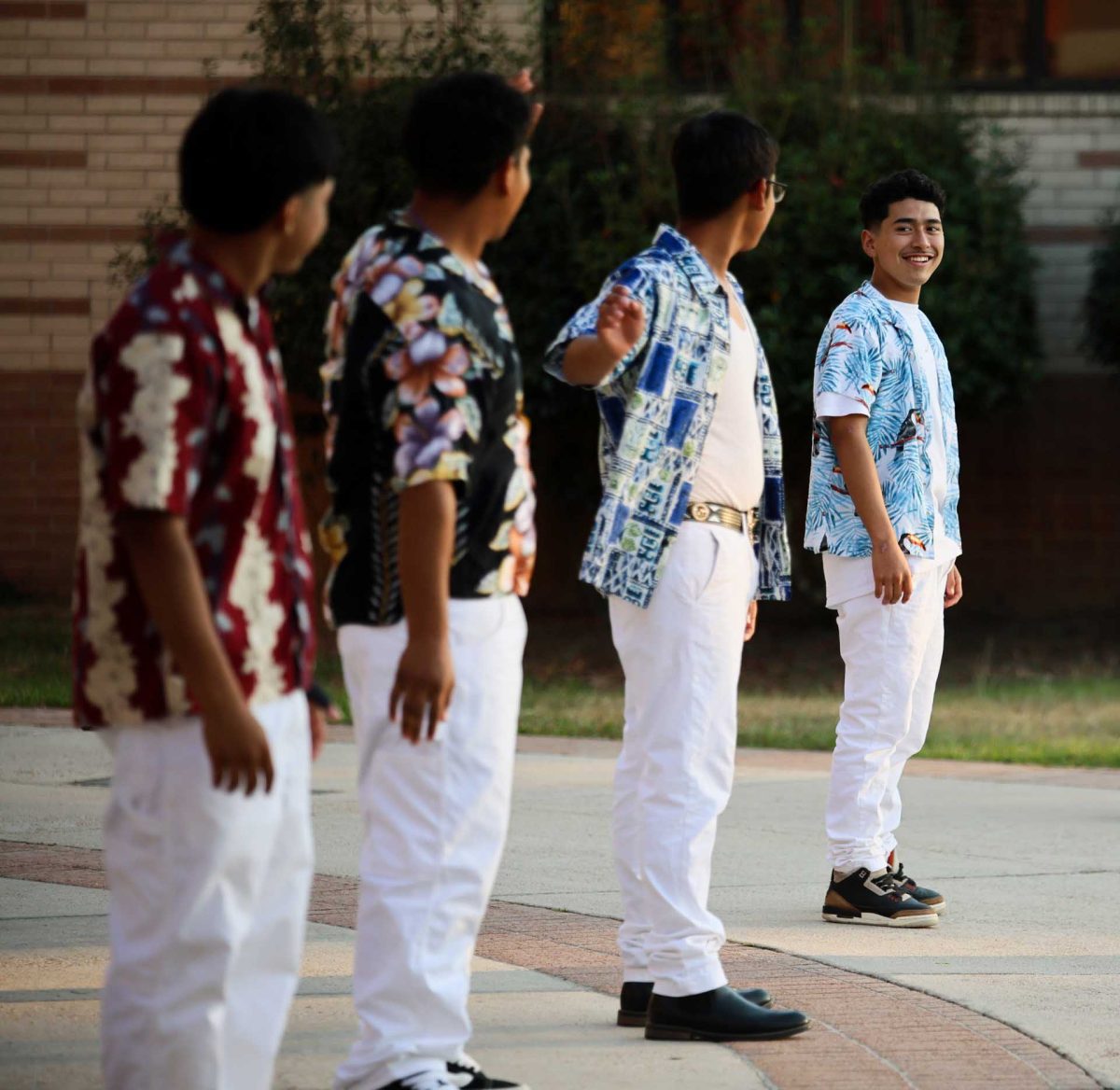 SMILE AND WAVE. Junior Carlos Benitez Palacios laughs and looks towards the other guys who are on the Panteras En Fuego team on Oct. 17, 2025 as they do “the wave” for their dance to “La Playa”, which has a mix of songs.