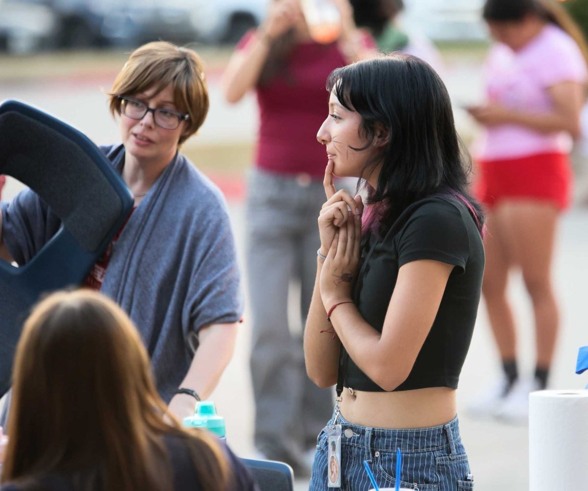 THINKING FACE. Junior Mariana Martinez Benitez speaking to the art teacher as they begin packing up their face painting booth and putting away furniture after the show ends on Oct. 14, 2025.