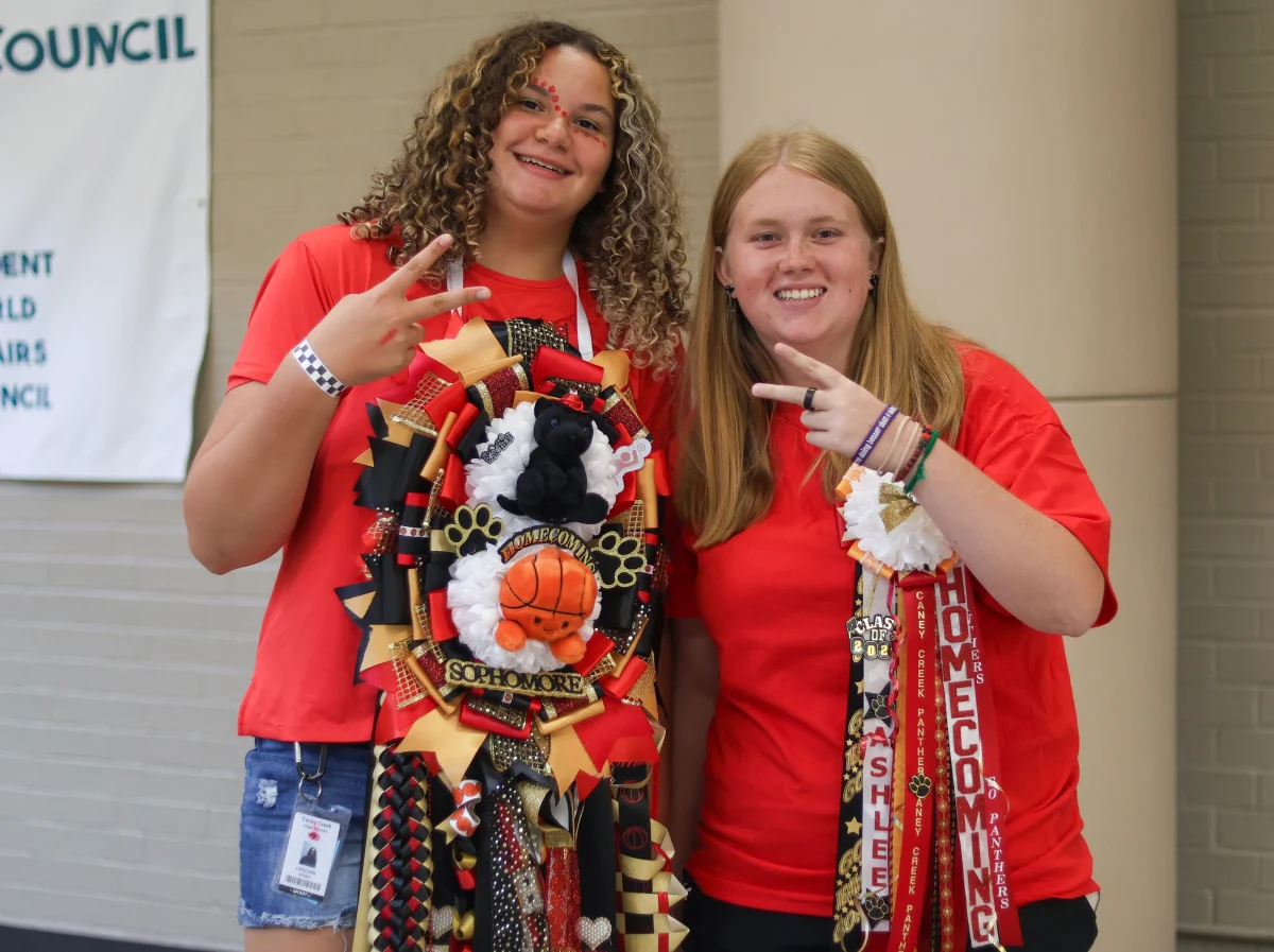 POSE. Sophomore Sydney Lipscomb and sophomore Ashlee McCoy pose for a photo together wearing  their Homecoming mums. Students were wearing their mums and red for the Red Out Homecoming Spirit day on Oct. 3, 2025.