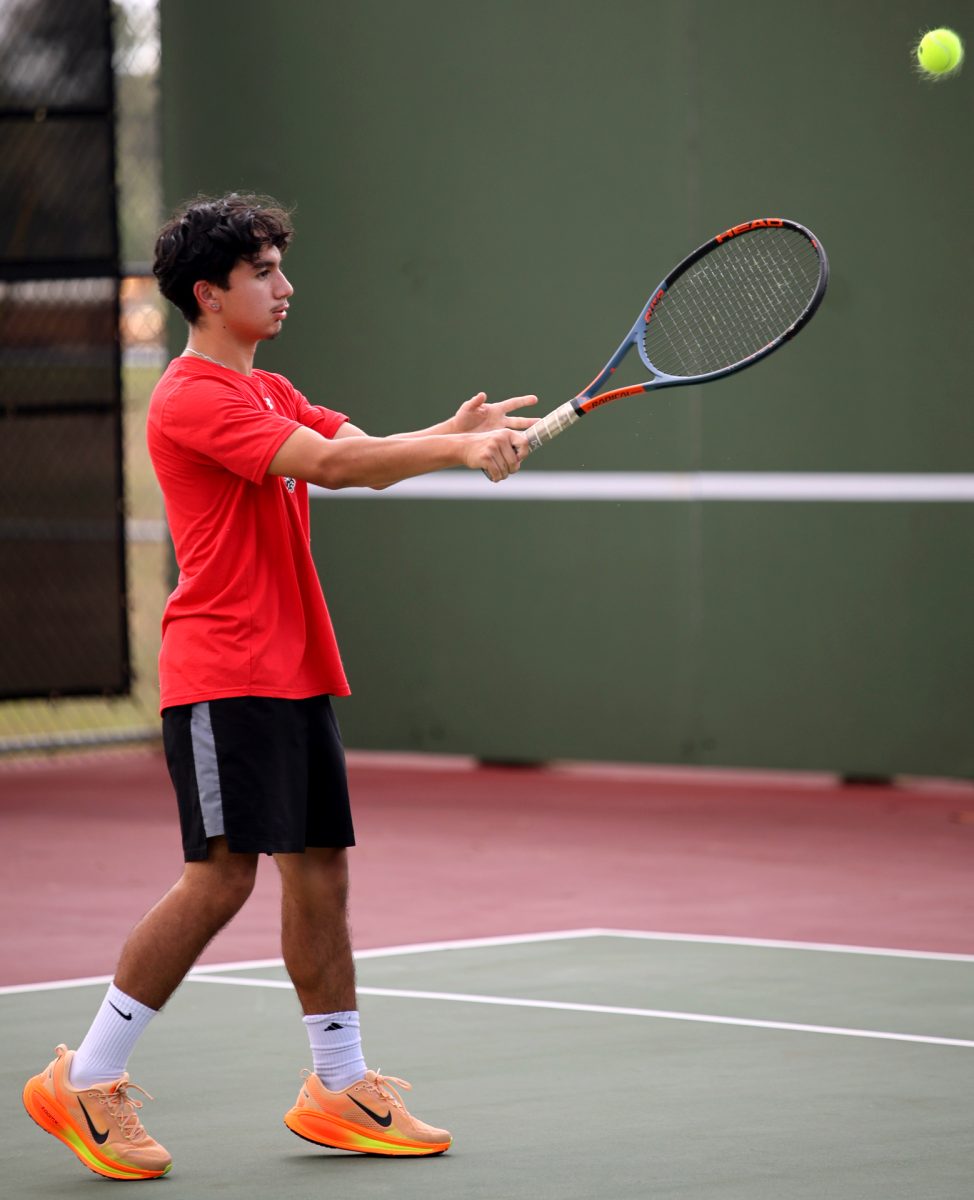 WARM UP. Junior Jayden Nieves throws the tennis ball back and forth with opponent before the Oak Ridge game on Thursday, Sept. 23, 2025.