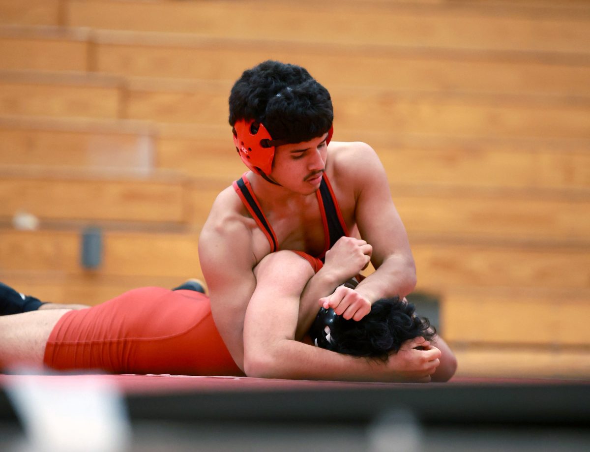 PINNED. Junior Wilson Zambrano pins down his opponent during the wrestling match at Caney Creek High School on Jan 8, 2026. Zambrano, gripping his arm around his opponent while pushing his head into the mat, was determined to keep him down.“I wasn't going to let him come up,” Zambrano said.