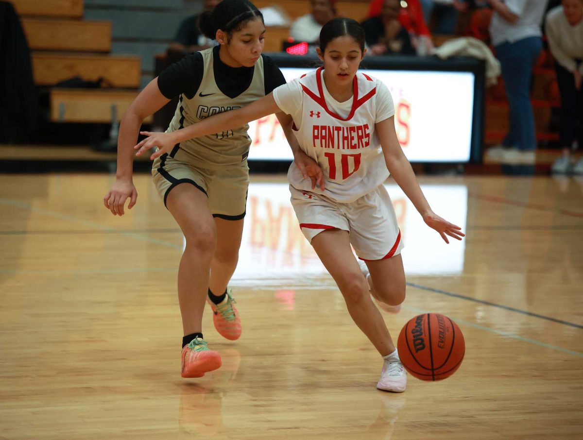 DRIBBLE FURY. Freshman Ana Nunez dribbles past her opponent with ease against Conroe High School on Jan. 09, 2026. “They were a tough opponent and I was nervous at first , but then I just trusted my skills and played with everything I had,” Nunez said.