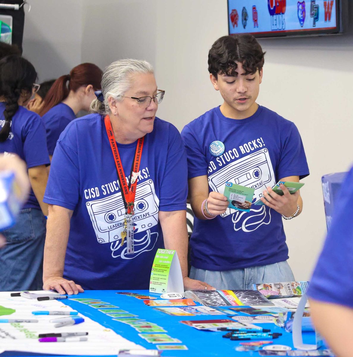 BE A LEADER. Junior Josias Godinez shows a staff member a brochure during the mid-level conference that was held on Monday, Feb. 9, 2026. The brochure contained information about the importance of buckling up while driving and the dangers of driving while intoxicated. 