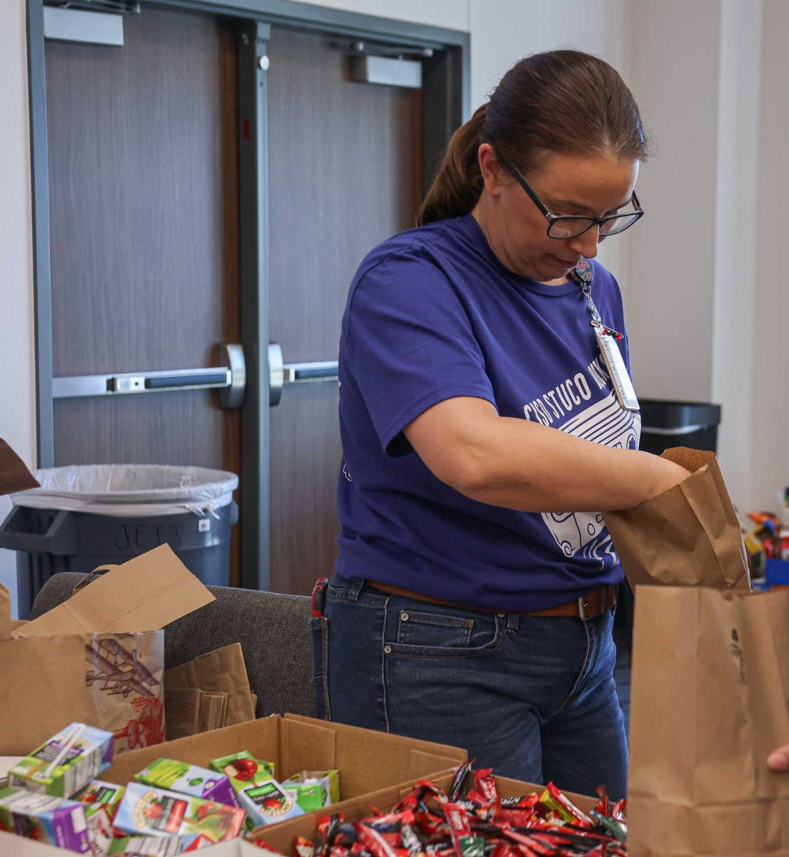 HELPING OTHERS. Assistant principal Dr.Karen Bray helps fill up paper bags for senior citizens during the Mid-Level conference that was held on Monday, Feb. 9, 2026. Dr. Bray was one of the four special guests who came to the Mid-Level conference. 
