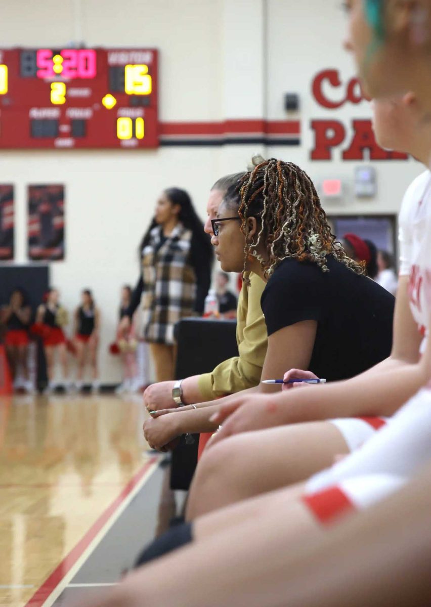 BUILDING IQ. Coach French sits and watches the varsity game play and takes stats for the team against Conroe on Jan. 9, 2026. French has been a JV coach the past years and has really inspired not only her own team, but other students that play up as well. “I saw spurts of potential. I never question the hard work because I don’t believe anyone plays harder than us, but we fall short on the mental and IQ aspects that come with experience,” French said. “This varsity team is hungry, but we need more to bring something to the table; games like this particular night was about showing up and playing for those who do want it more than you even if it’s not what you want.