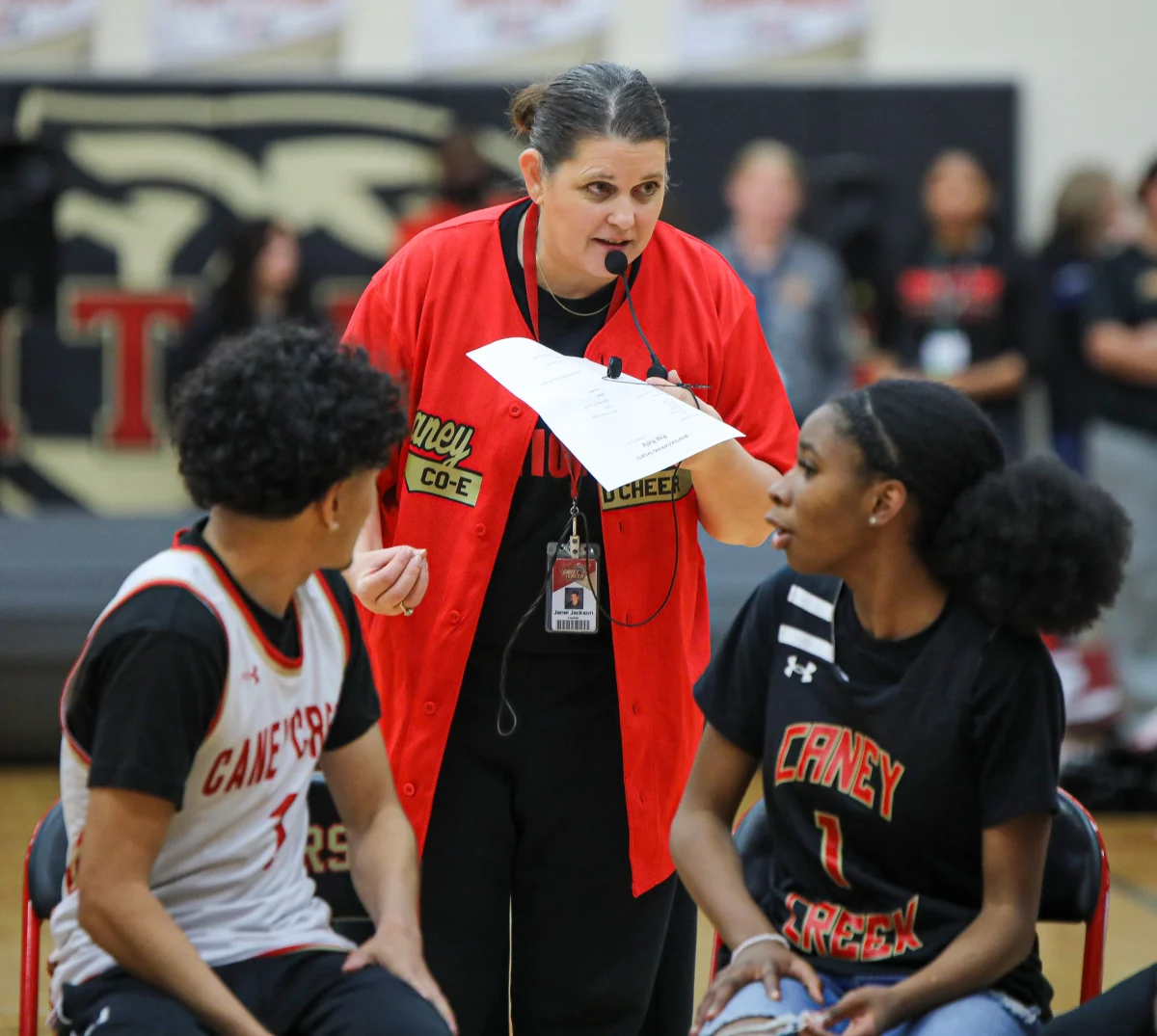 LISTEN CAREFULLY. Cheer Coach Janel Jackson gives basketball players game instructions for their competition against each other during the Winter Sports Pep Rally on Thursday, Feb. 5, 2026. Basketball players each had to score one point in order to run back to their chairs and not be eliminated. 