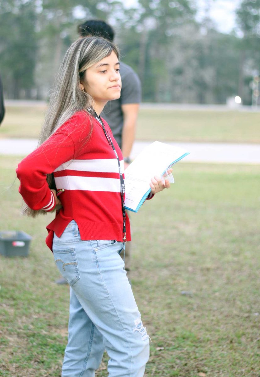 WATCHFUL. Senior Giselle Moctezuma looks at her classmates picking up beans on Thursday, Feb.19, after she completed the assignment. The AP Biology class spent their day outside conducting experiments. 