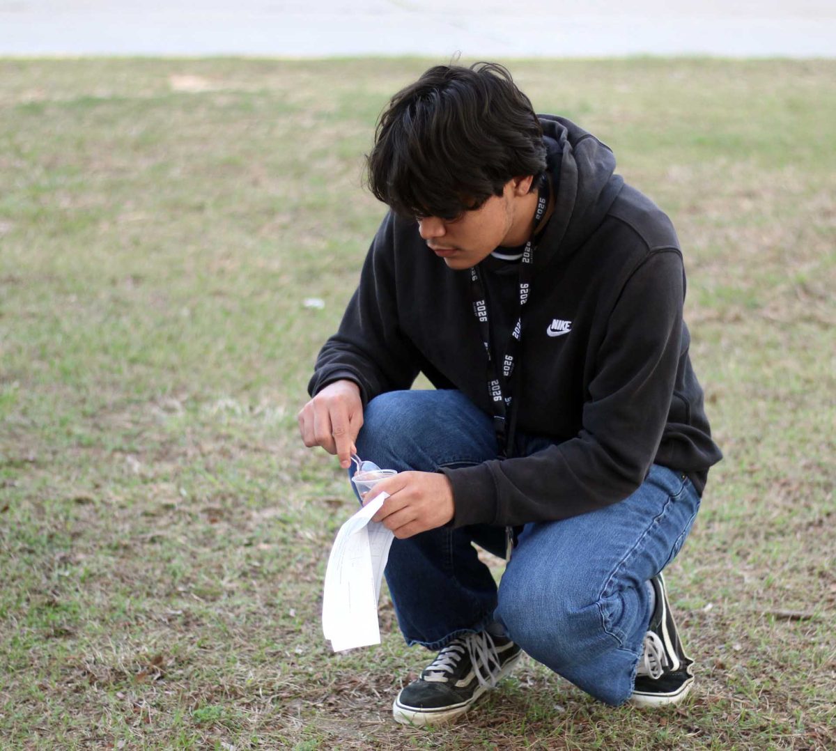 SCOOPBAA. Santiago Morales Castro pours his beans into a plastic cup on Thursday, Feb. 19, before going to count them. Students had to write down the number of beans collected for their AP biology class assignment. 