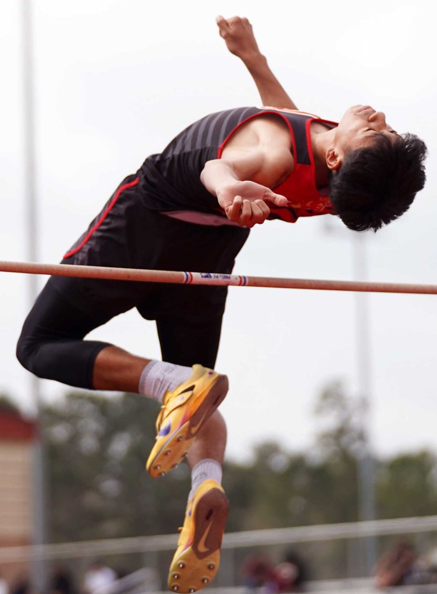 STRETCHY. Junior Jason Guevara flows past the pole in his flow state at the Panther Relay Meet on Thursday Feb, 26. Guevara fully extended his body to not hit the pole during the meet.  