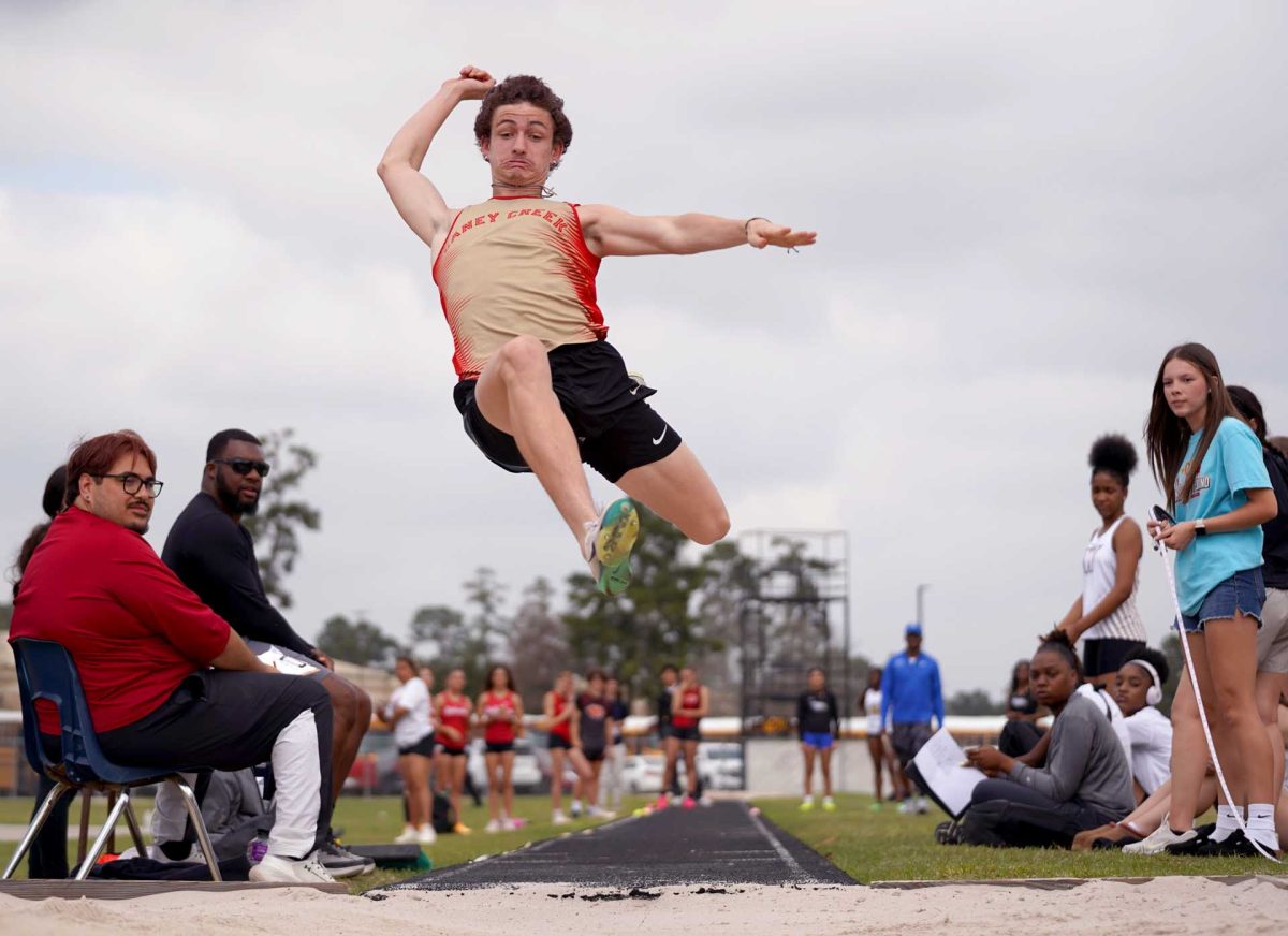 FLY FLY AWAY. Senior Logan Berggren flying high in the air looking to break his personal record at the Panther Relay Meet on Thursday Feb, 26. Berggren completed and placed 1st in his two mile run before his long jump.  
