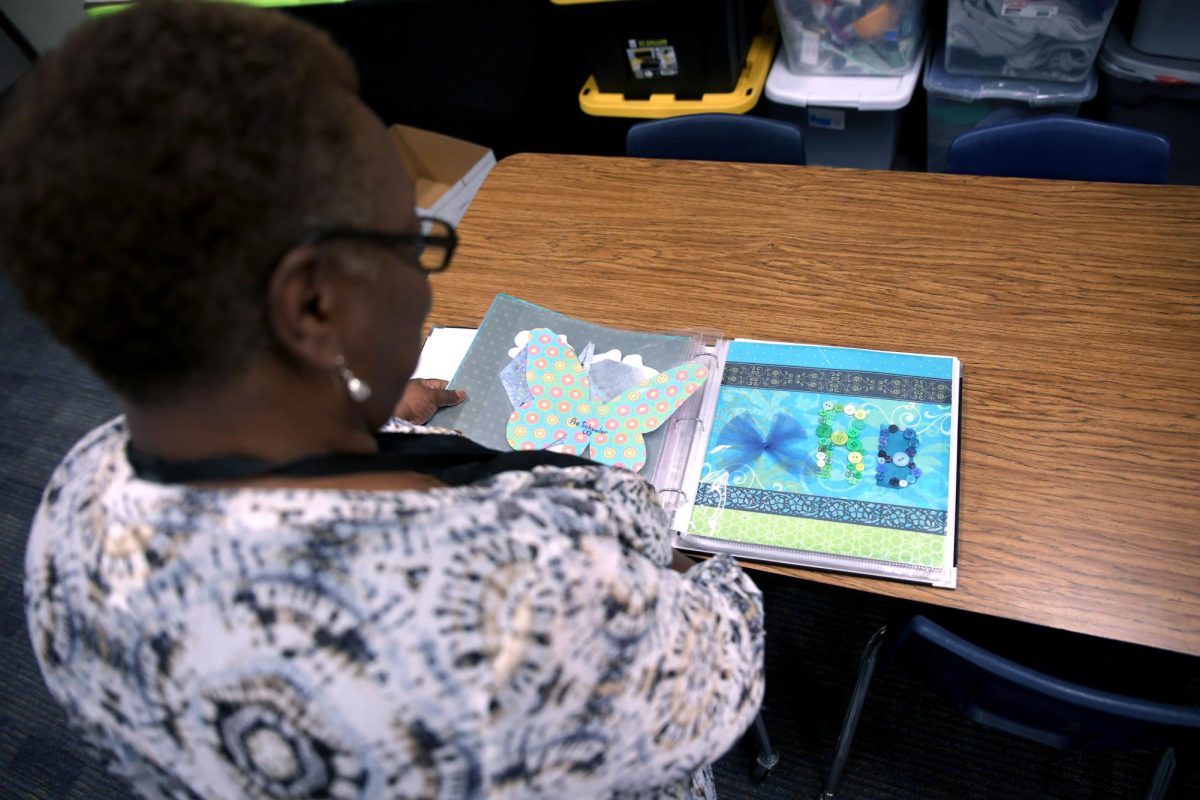 SCRAPPED. Communities in Schools site coordinator Regina Burks looks through a scrap students made for her in the CIS room April 22.