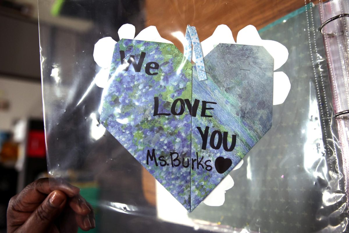 FROM THE HESRT. Communities in Schools site coordinator Regina Burks holds up a homemade heart-shaped letter while touring the CIS room April 22.